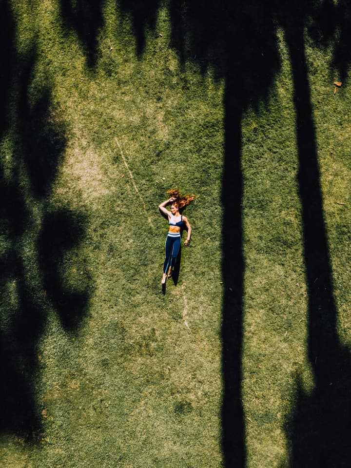 Personne allongée dans l’herbe sous une lumière apaisante